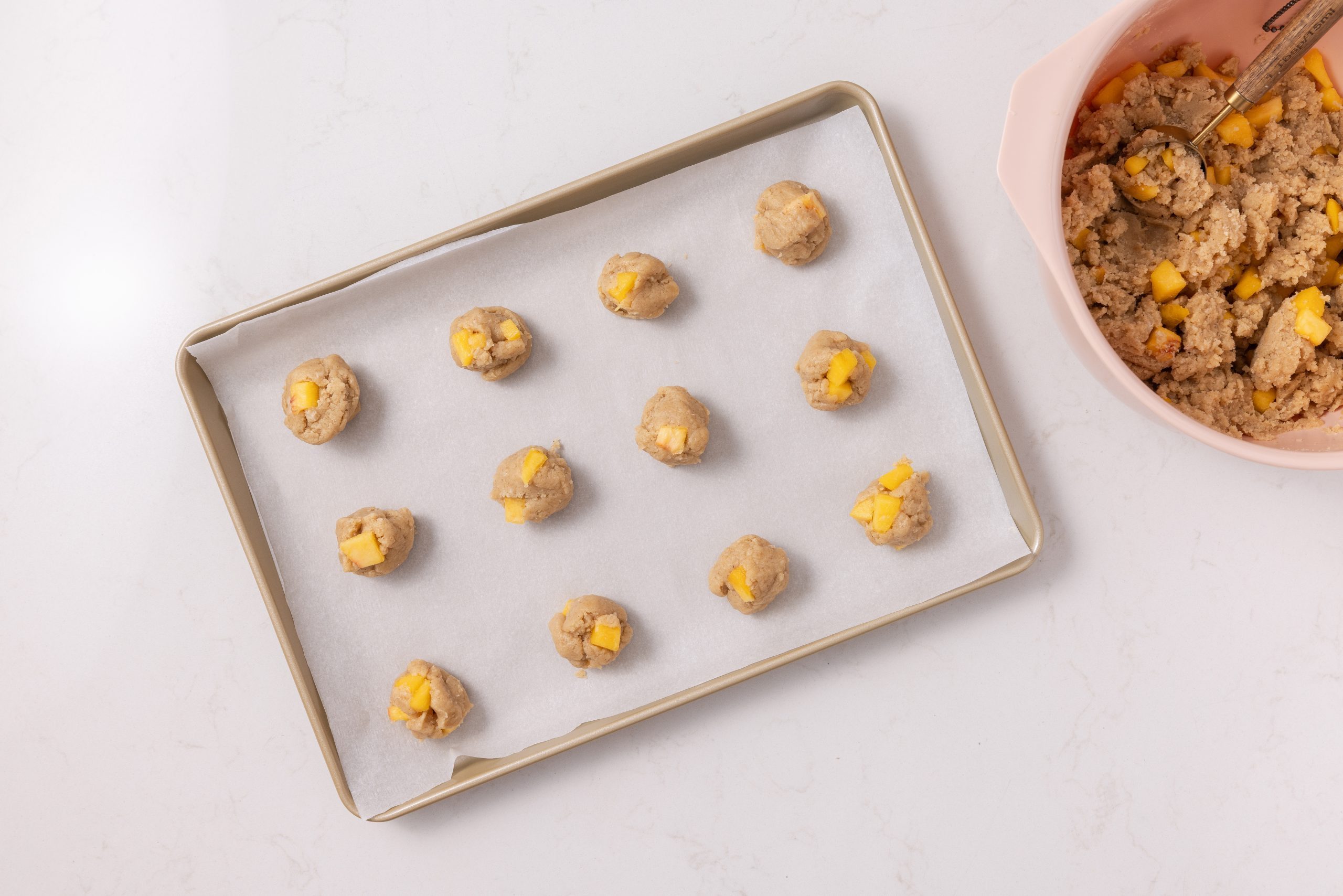 Cookies being put in baking sheet.