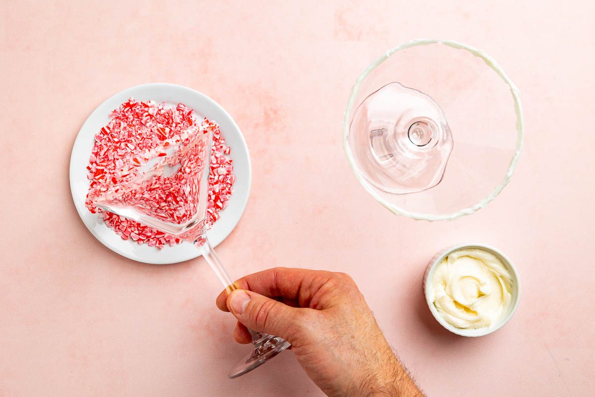 Taste of Home Peppermint Martini recipe photo of preparing the martini glass rimmed with crushed peppermint candies.