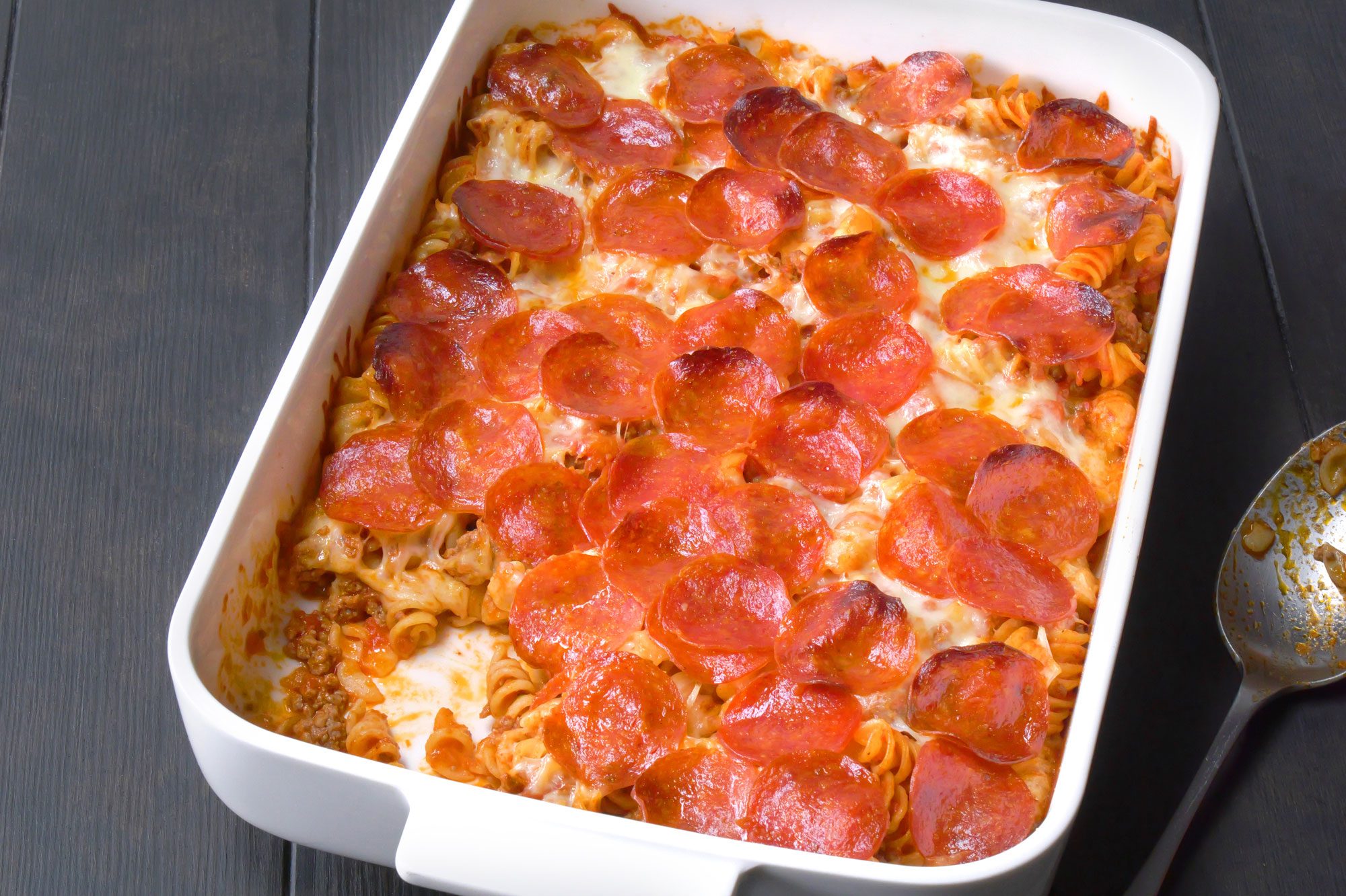 Pizza Casserole in a baking dish with silver spoon