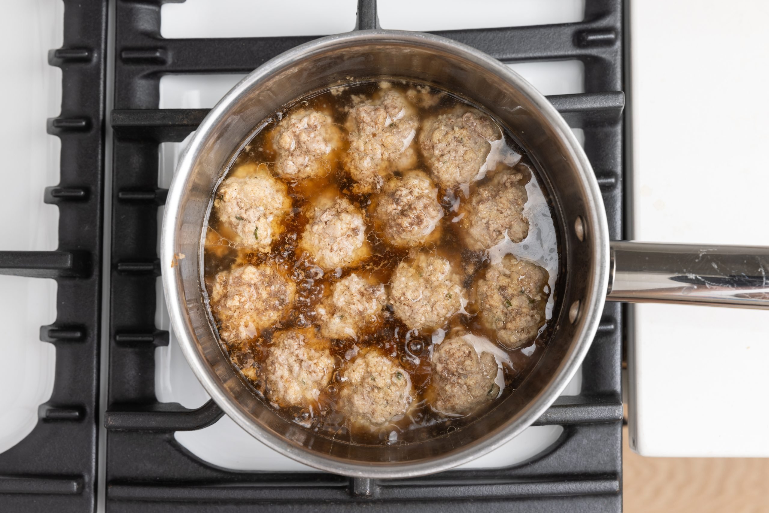 Meatballs cooking in beef broth.