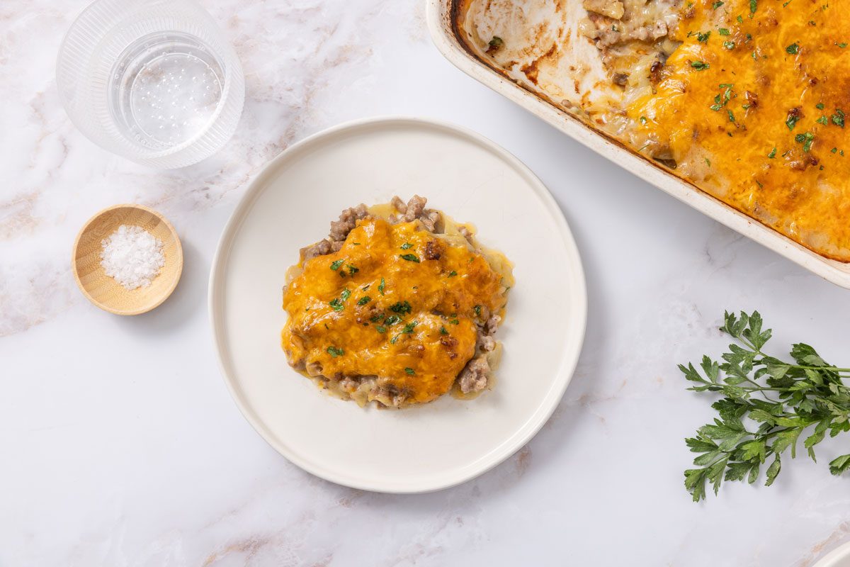 Casserole Served In White Plate With Aking Dish Next To It.