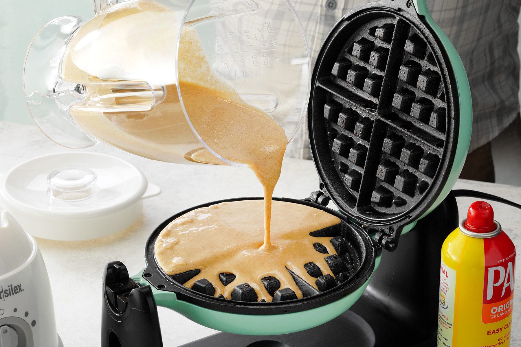 Pouring waffle batter on waffle iron