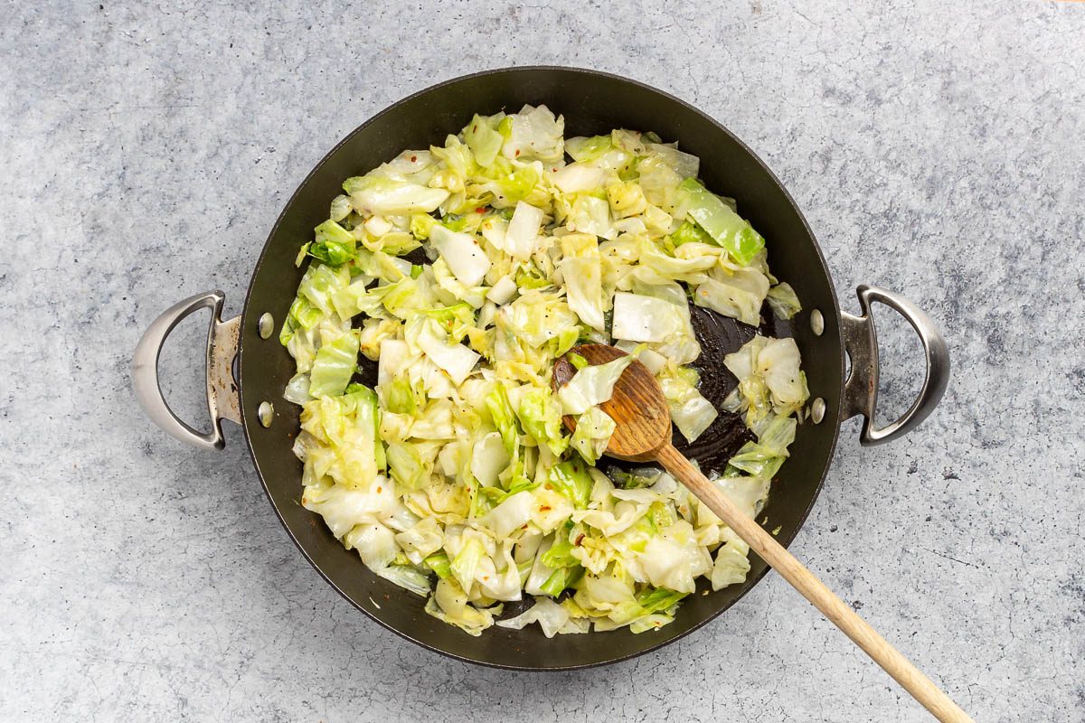 Taste of Home Sauteed Cabbage recipe photo of the water and cabbage added to the skillet and cooked with all the ingredients.