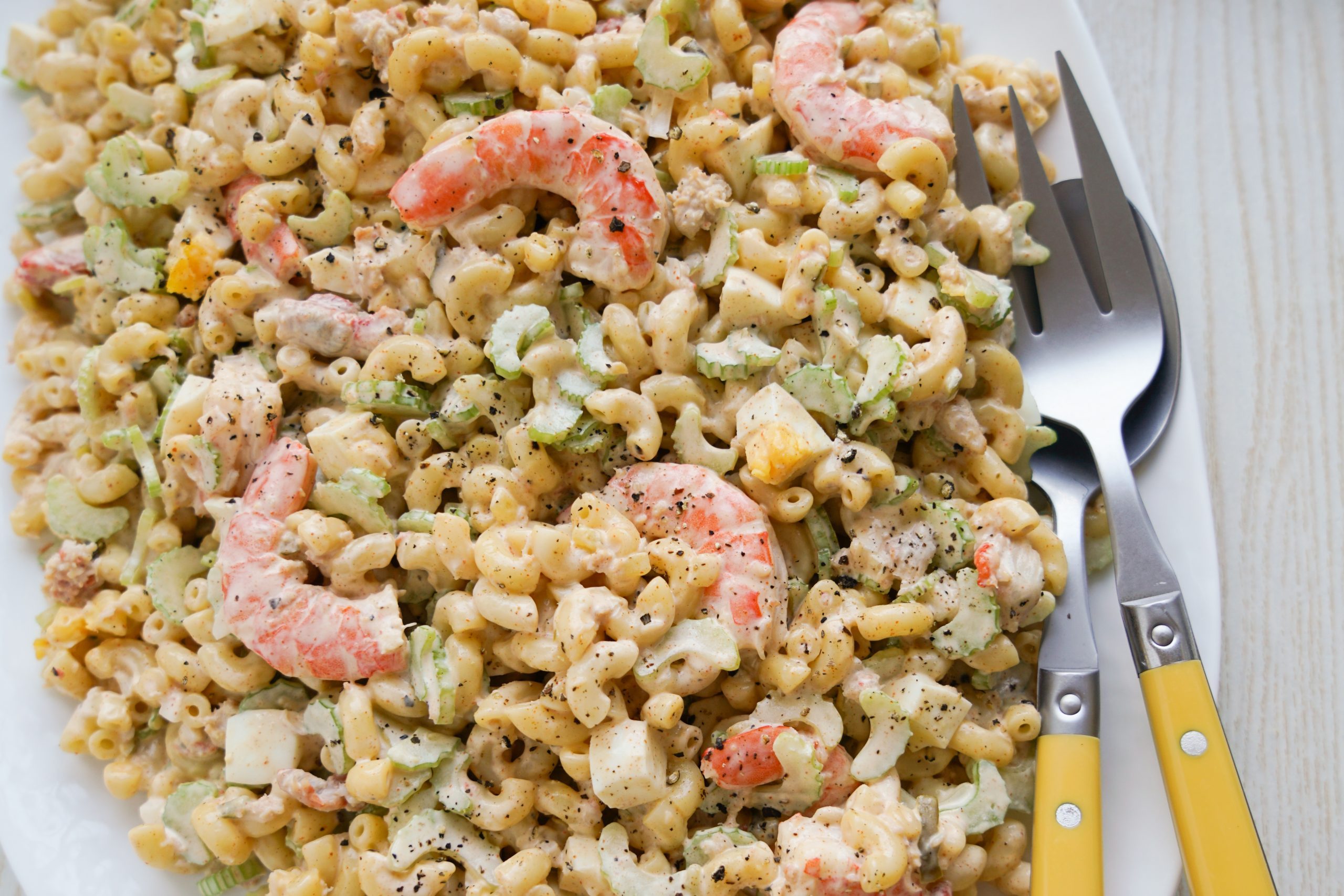 Seafood pasta salad with serving utensils