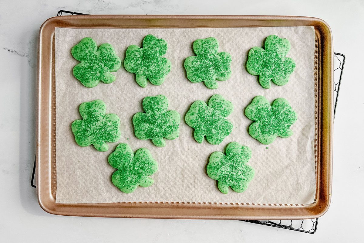 Taste of Home Shamrock cookies on a baking sheet on a wire rack set on a marble surface.