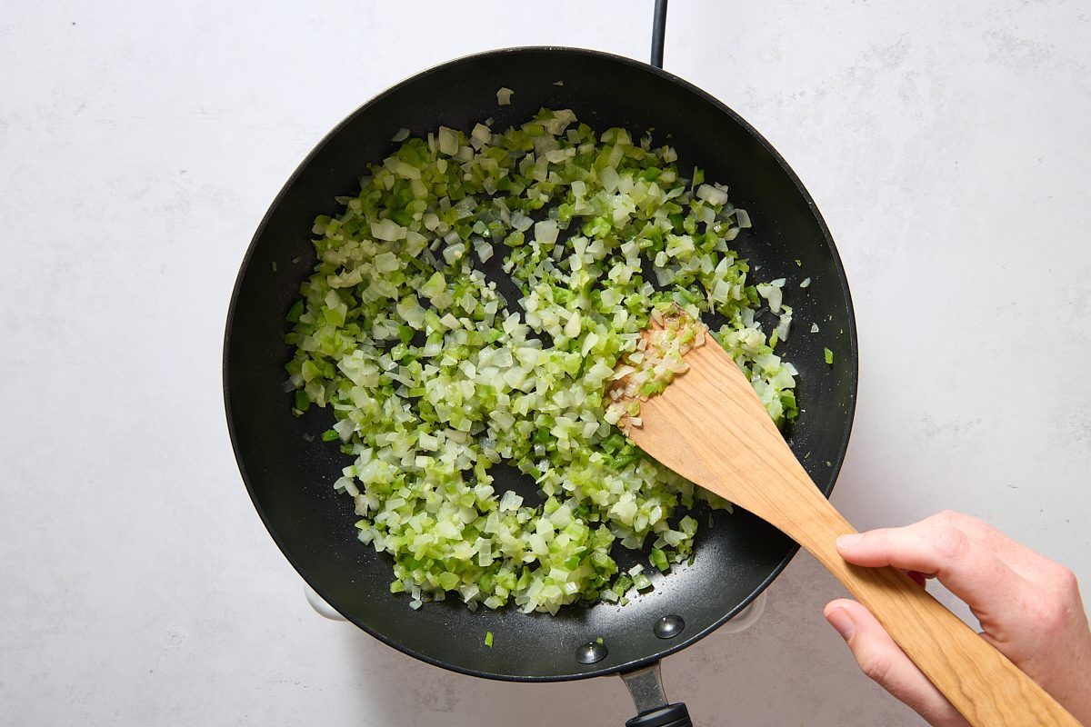 Softening the peppers and onions in a skillet