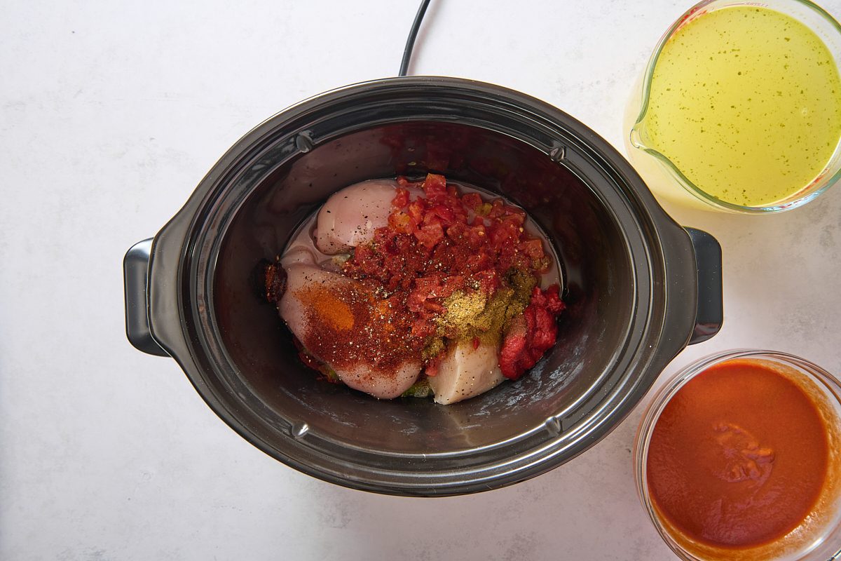 Soup ingredients being added to a slow cooker