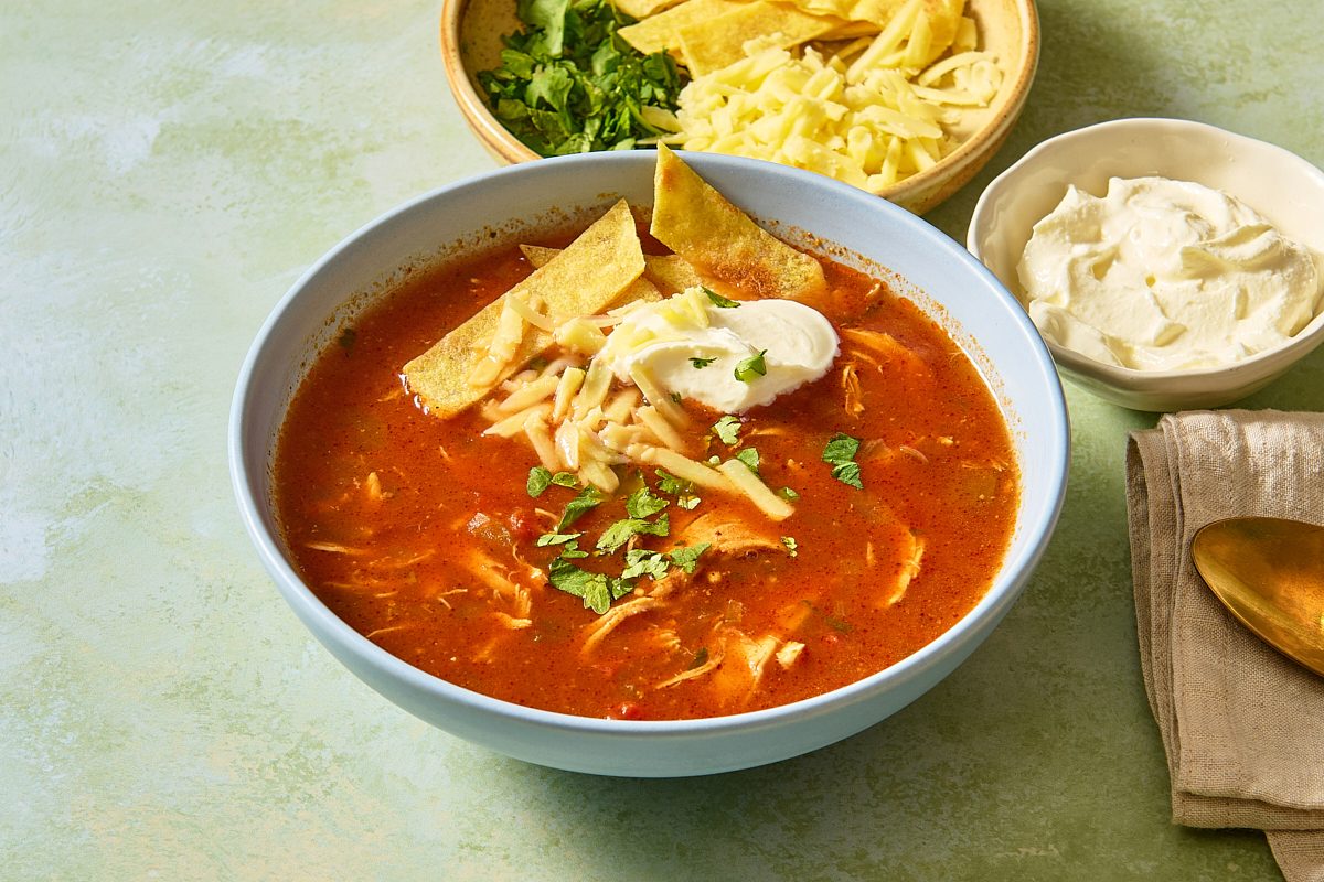 Slow Cooker Chicken Enchilada Soup in a bowl with toppings