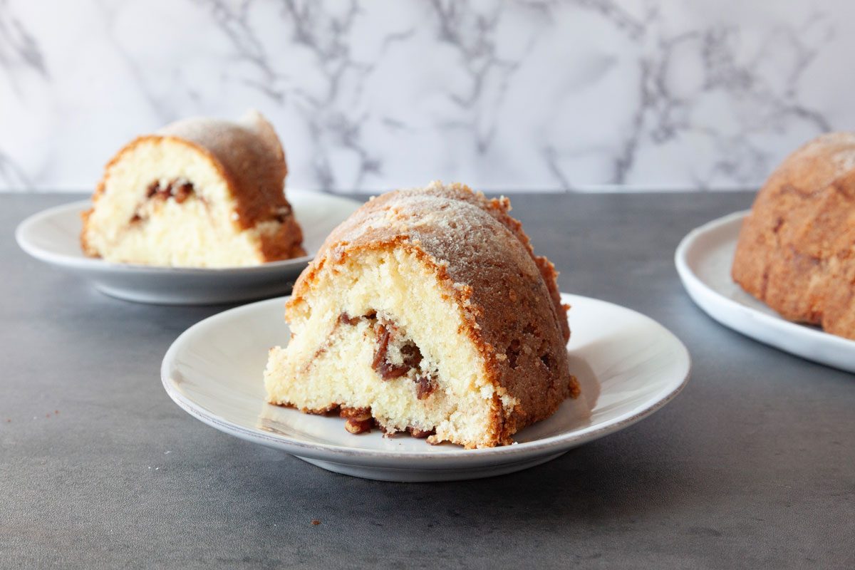 Single servings of Taste of Home Sour Cream Coffee Cake Bundt on small white plates, black surface