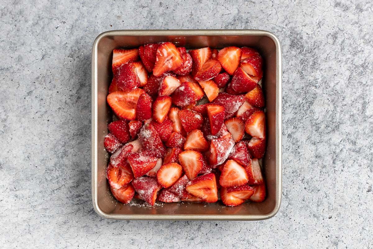 Taste of Home Strawberry Crumble recipe photo of preparing the strawberries and transferring them into an 8 inch baking pan.