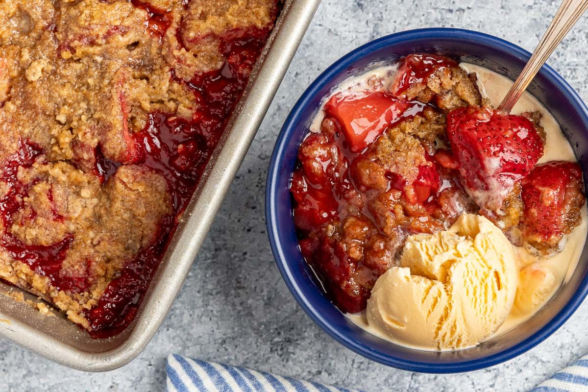 Taste Recipes Strawberry Crumble recipe photo of the finished recipe served with scoops of vanilla ice cream.