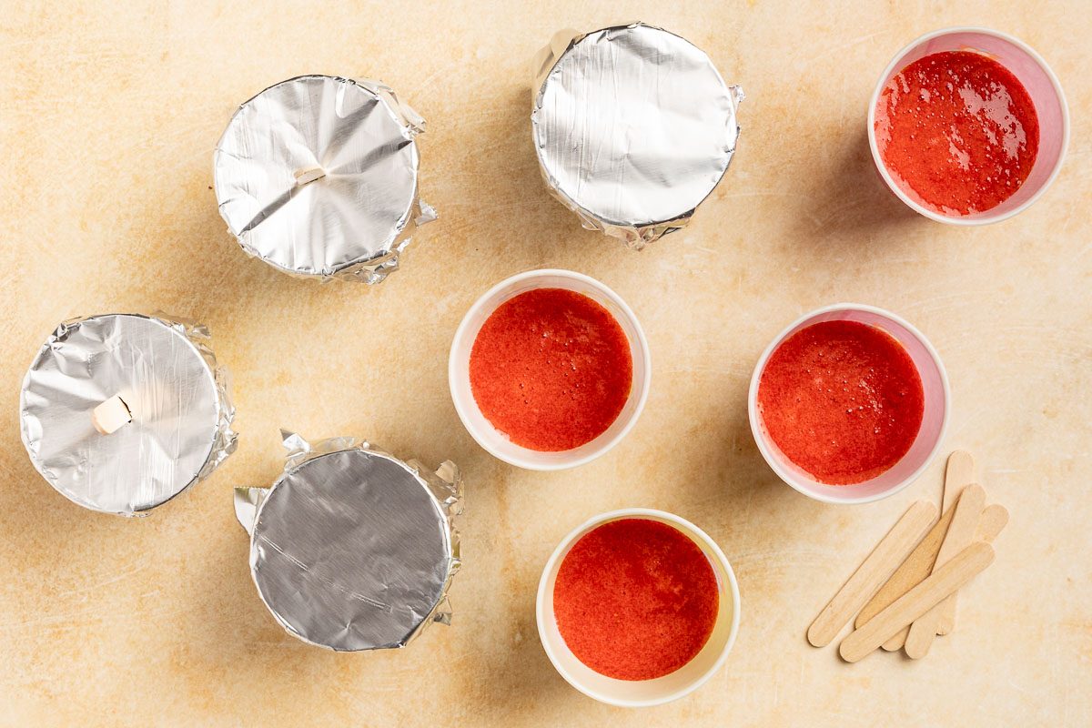 Taste of Home Strawbery Popsicles recipe photo of flilling the cups with the strawberry puree.