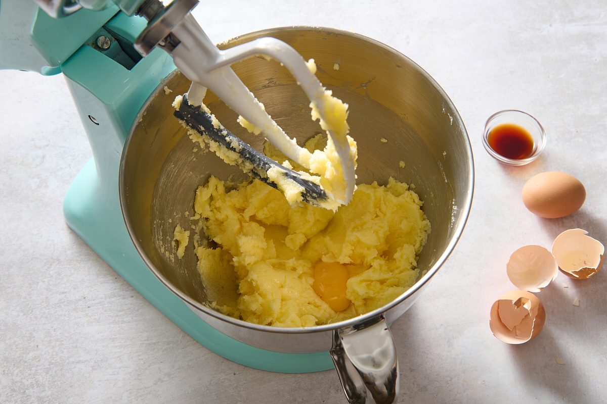 Adding eggs to the creamed mixture one at a time