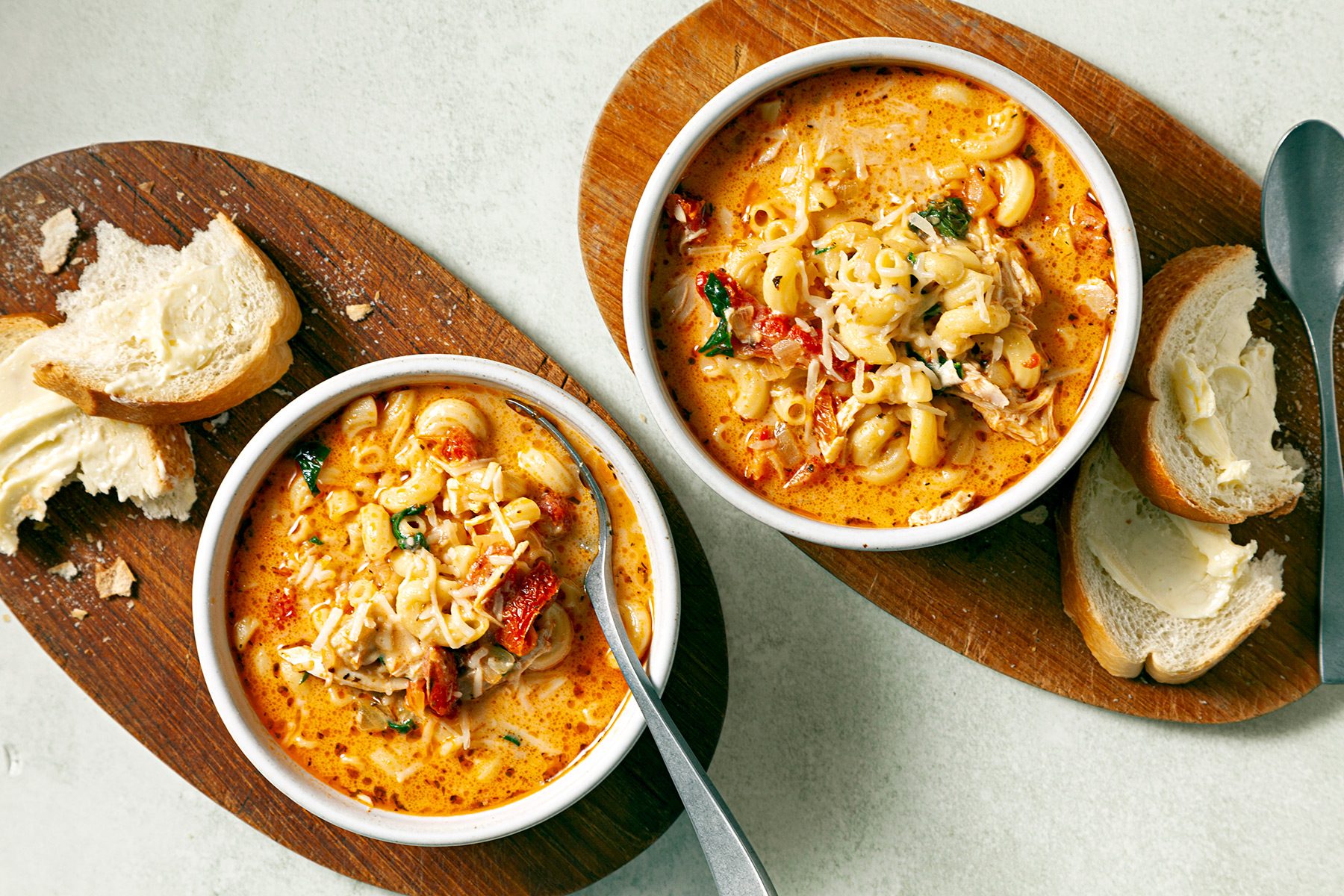 wide shot of creamy tuscan chicken soup with shredded cheese