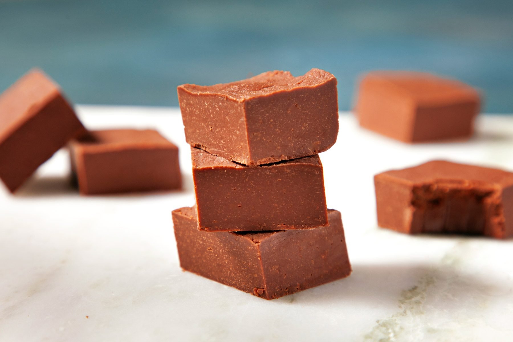 Sliced pieces of fudge on a white cutting board.