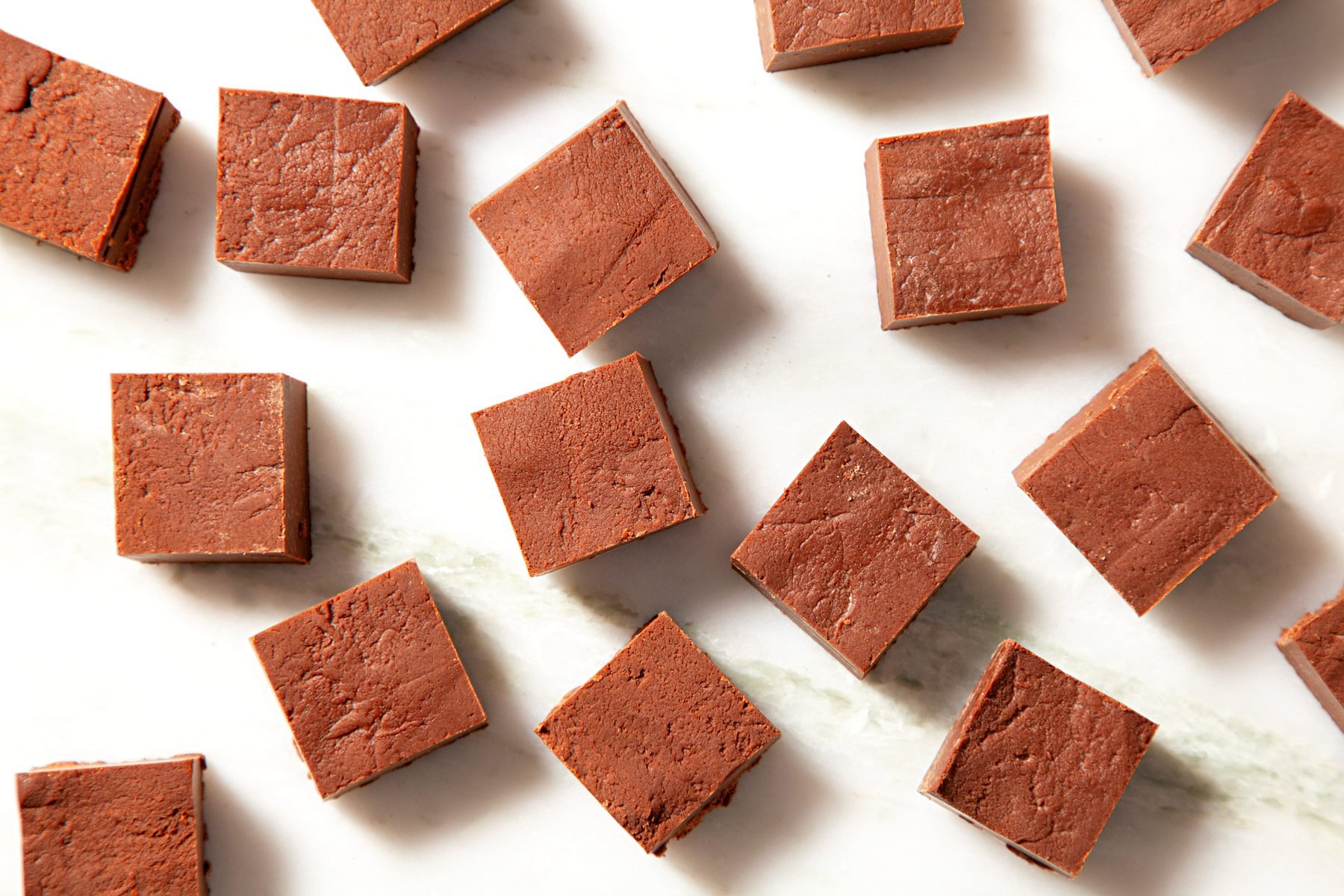 Sliced pieces of fudge on a white cutting board.