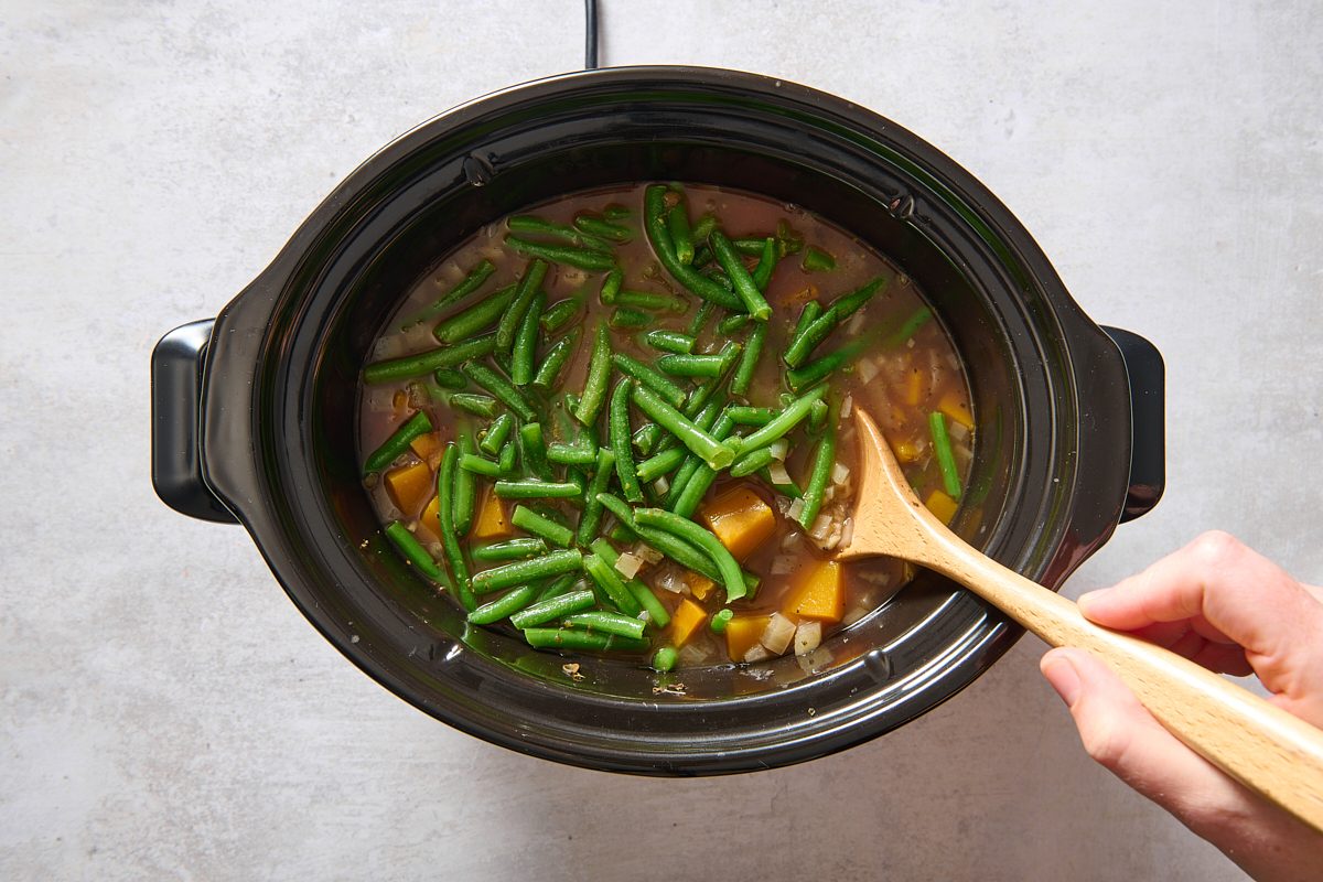 Stirring in tomatoes and green beans