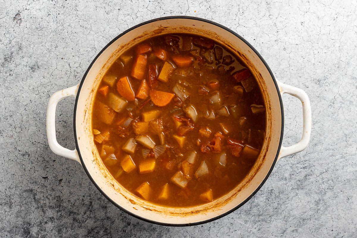 Taste of Home Vegetable Stew recipe photo of the water, carrots, potatoes, and squash added to the dutch oven.