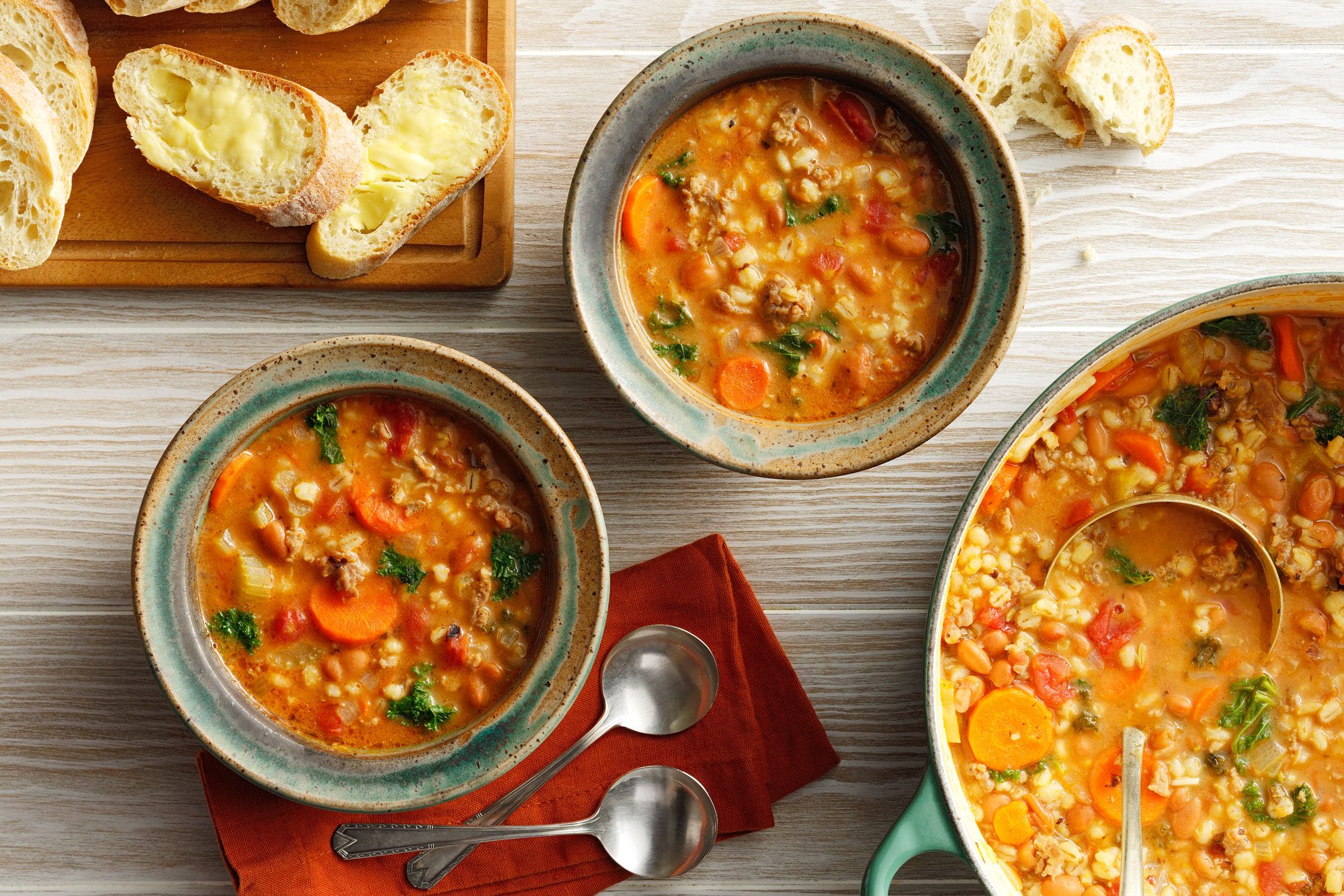 White Bean And Sausage Soup served in bowls with fresh bread