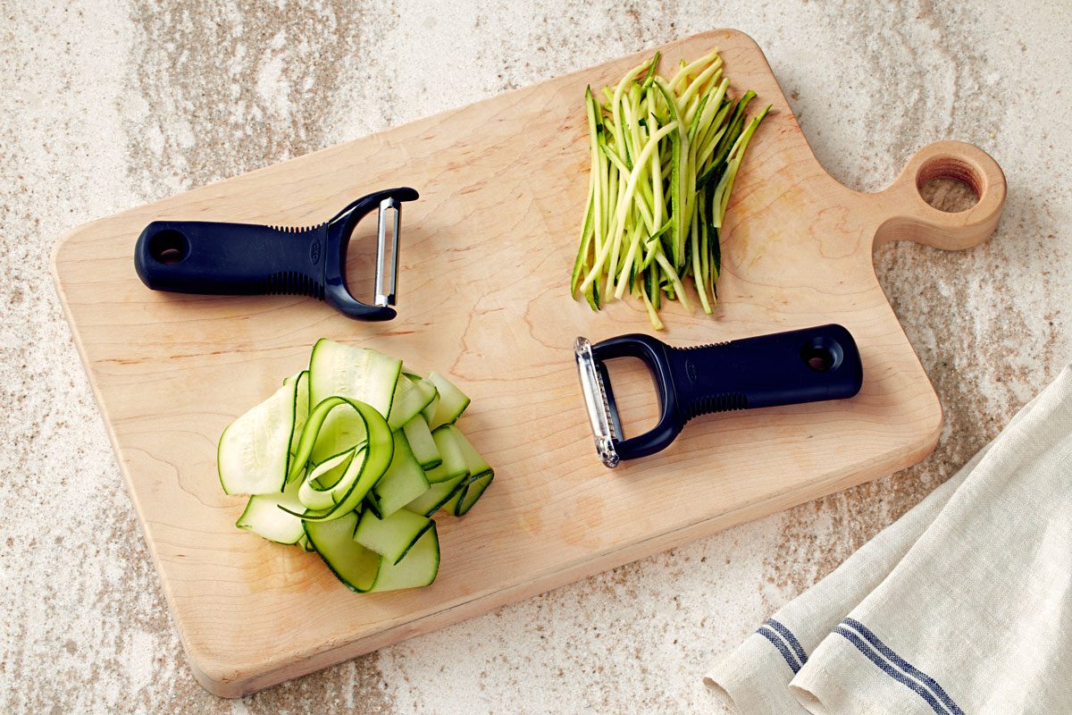 Zucchini Noodles made with different types of vegetable peelers, a regular peeler and a julienne peeler