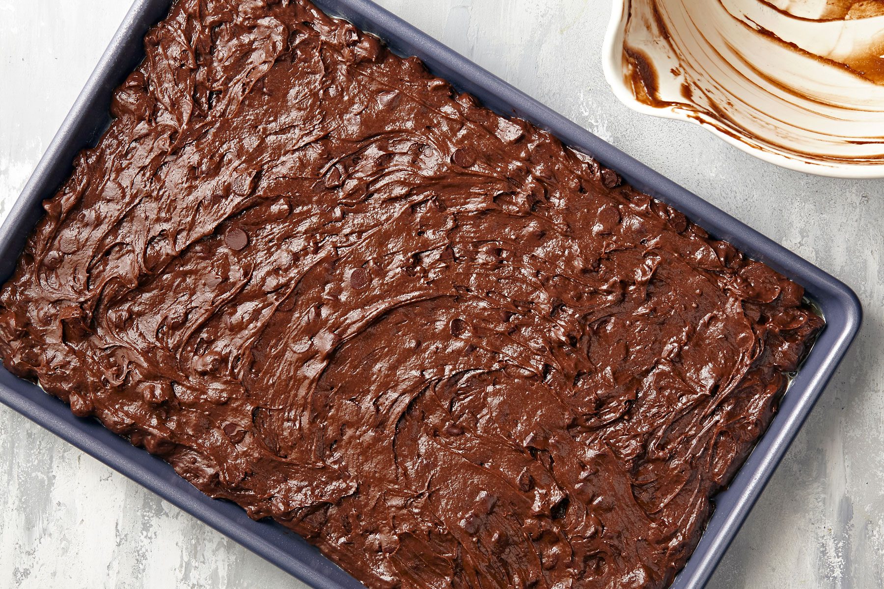 Brownie batter spread evenly in baking pan.