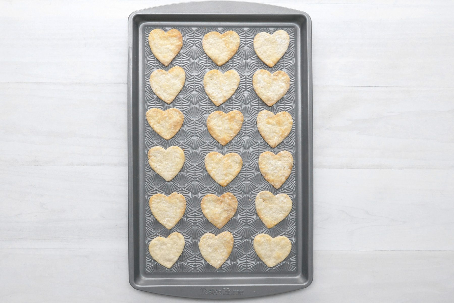 overhead shot; white wooden background; Placing heart shaped pieces on ungreased baking sheets