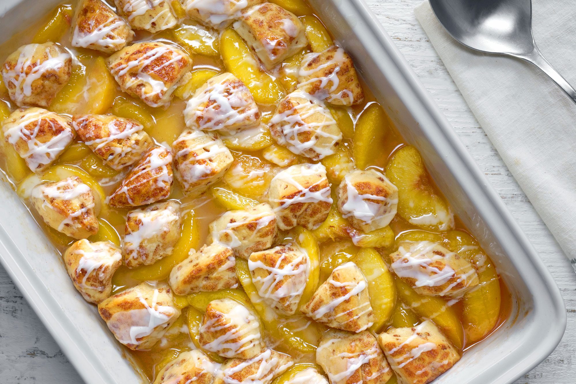 Cinnamon Roll Peach Cobbler served in a serving pan