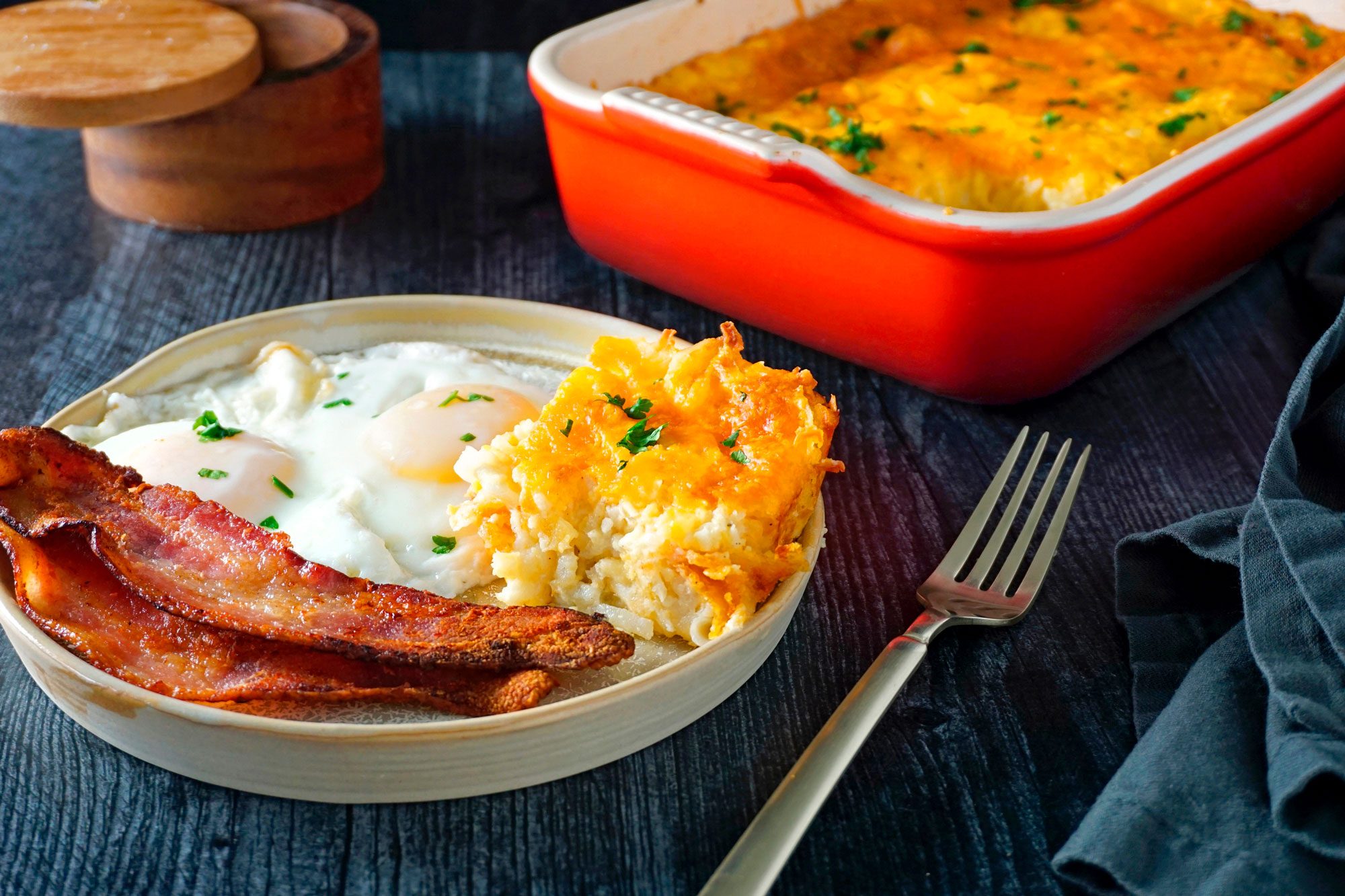 Copycat Cracker Barrel Hashbrown Casserole served in a plate with bacons