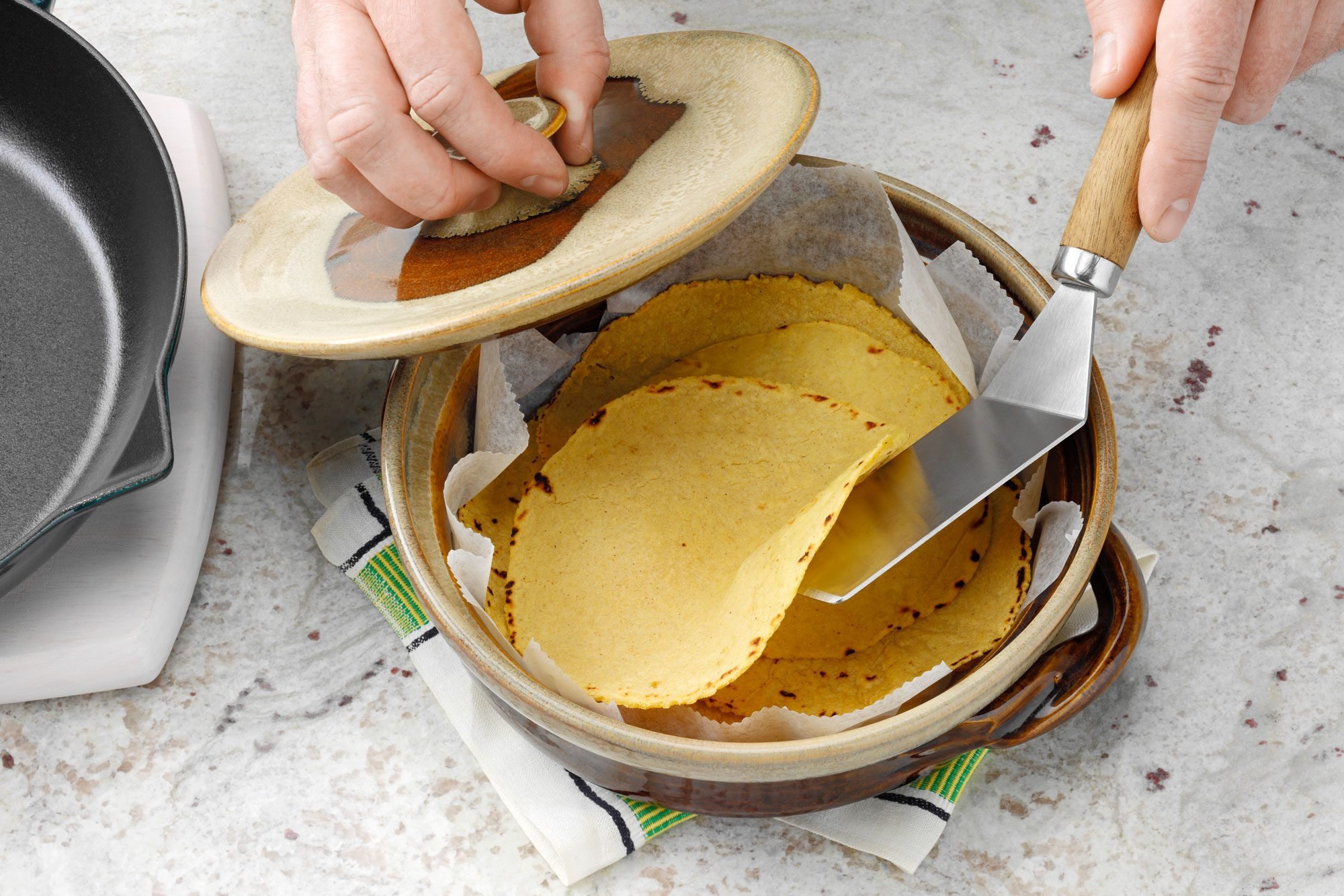 tortilla being transferred into a tortilla warmer