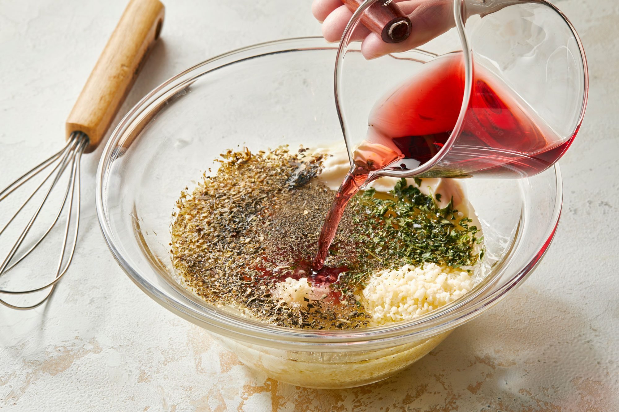 pouring wine vinegar in a large glass bowl