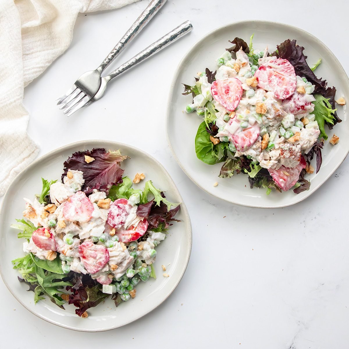 Overhead beauty shot for Taste of Home Tarragon Chicken Salad on a marble surface with forks and linen.