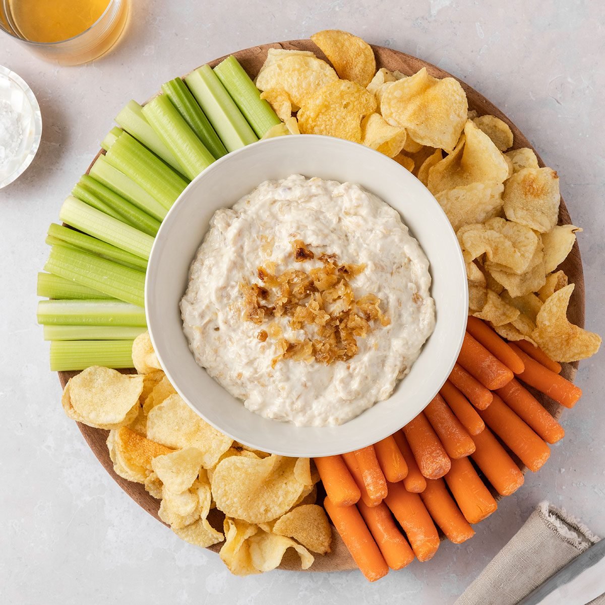 Caramelized onion dip served with fresh vegetables and potato chips.