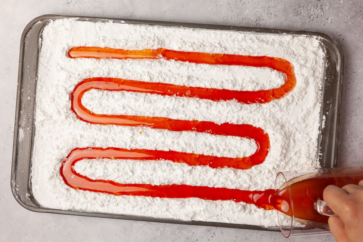 Step 4 of Taste Recipes Hard Candy is to pour the mixture into a glass measuring cup with a spout. Working quickly, pour the syrup into the indentation in the prepared pan. Cover the candy with more confectioners' sugar. When the candy is just cool enough to handle, cut it into pieces with scissors.