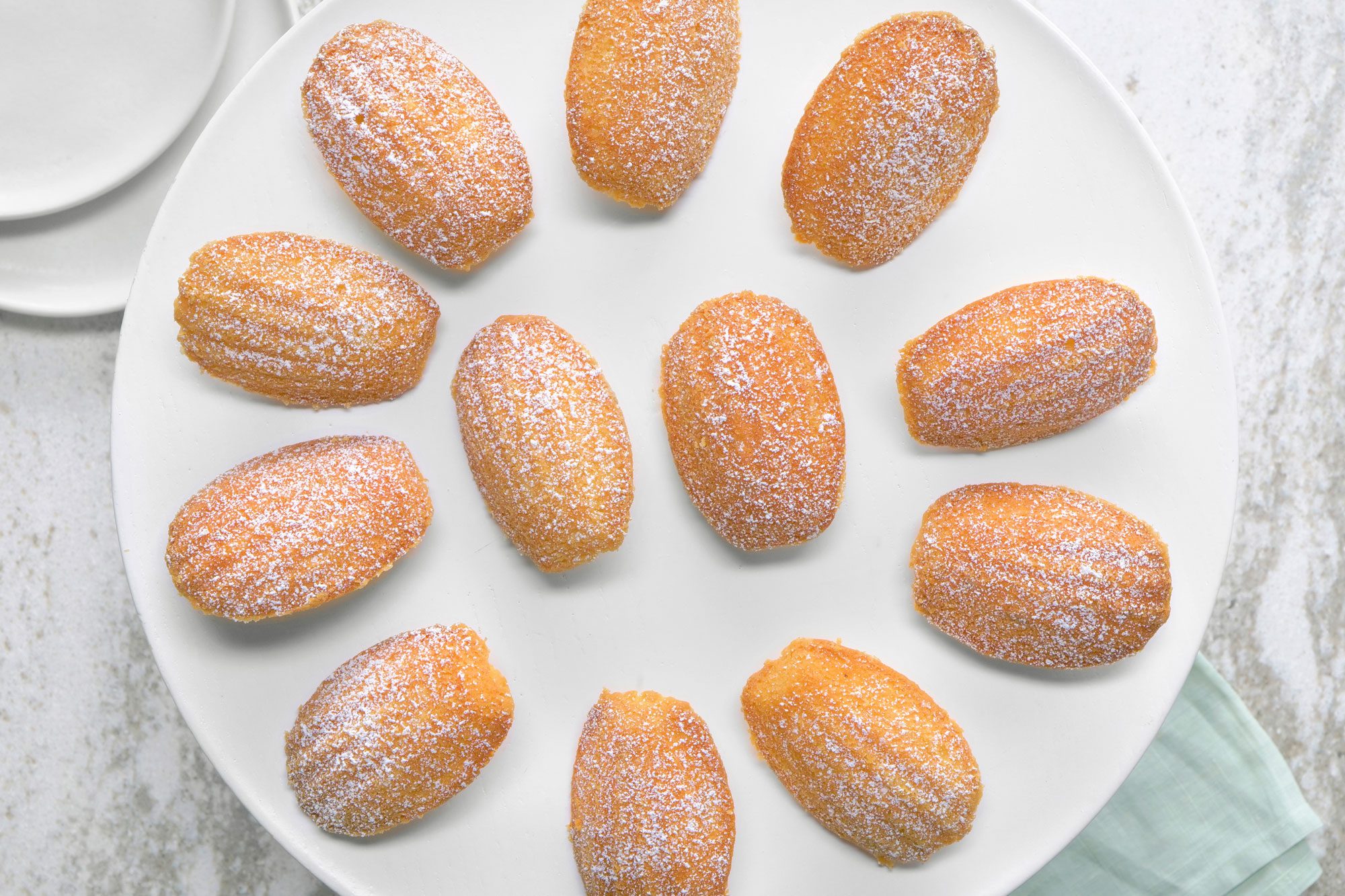 overhead shot of madaleine cookies dusted with confectioner's sugar