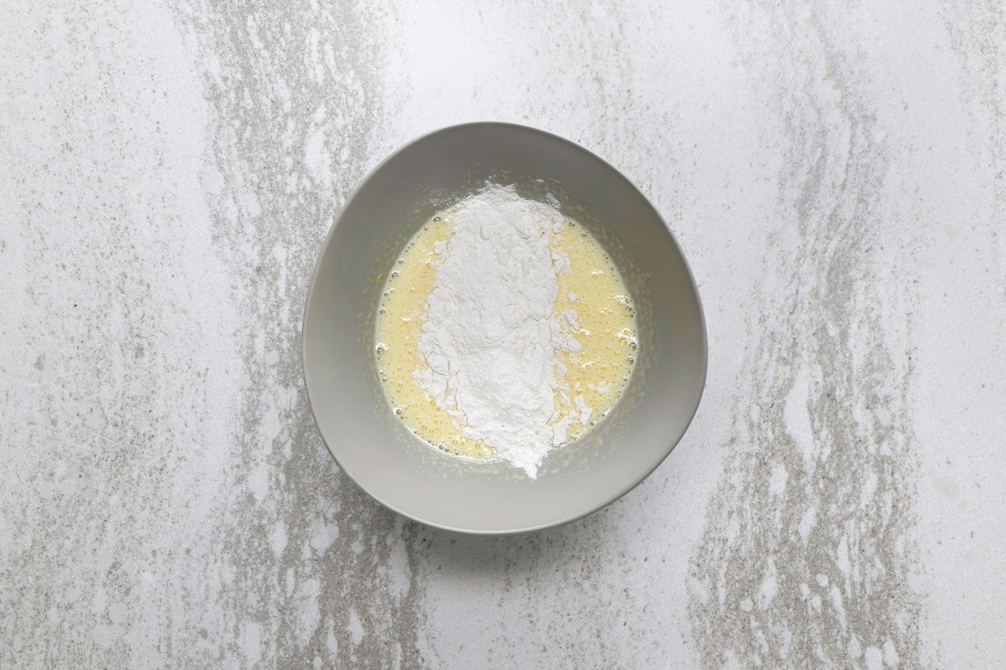 Fold half of the flour mixture into the egg mixture until mostly incorporated.