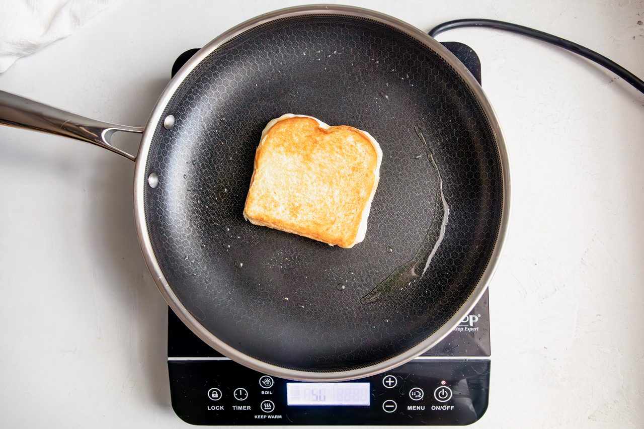 Overhead shot for Taste of Home Pesto Grilled Cheese, sandwich being toasted in skillet.