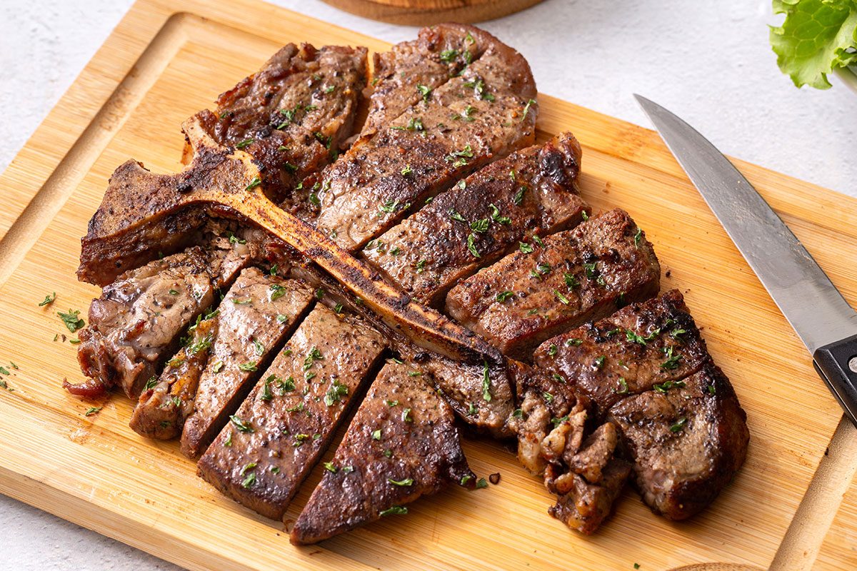 Cut porterhouse steak on a wooden cutting board for Porterhouse Steak recipe for Taste of Home