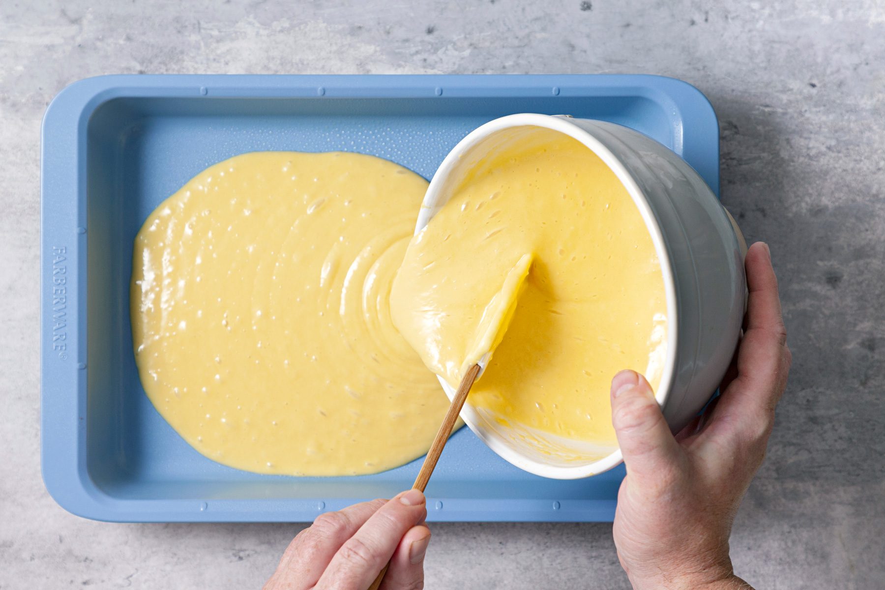 Overhead shot of prepare and bake cake mix according to package directions for a pan; spatula; grey surface