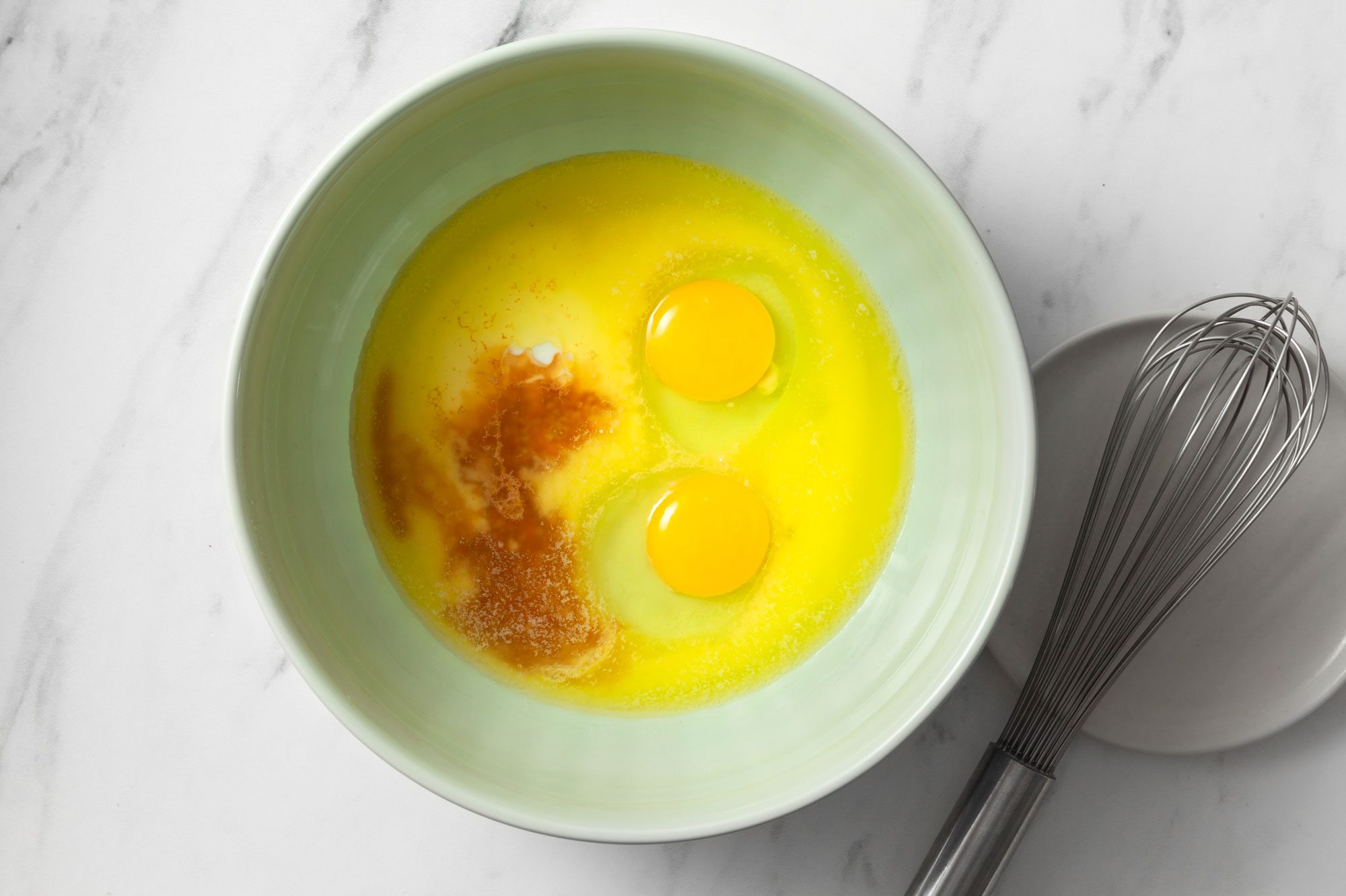 In a large bowl whisk together melted butter, eggs, buttermilk and vanilla