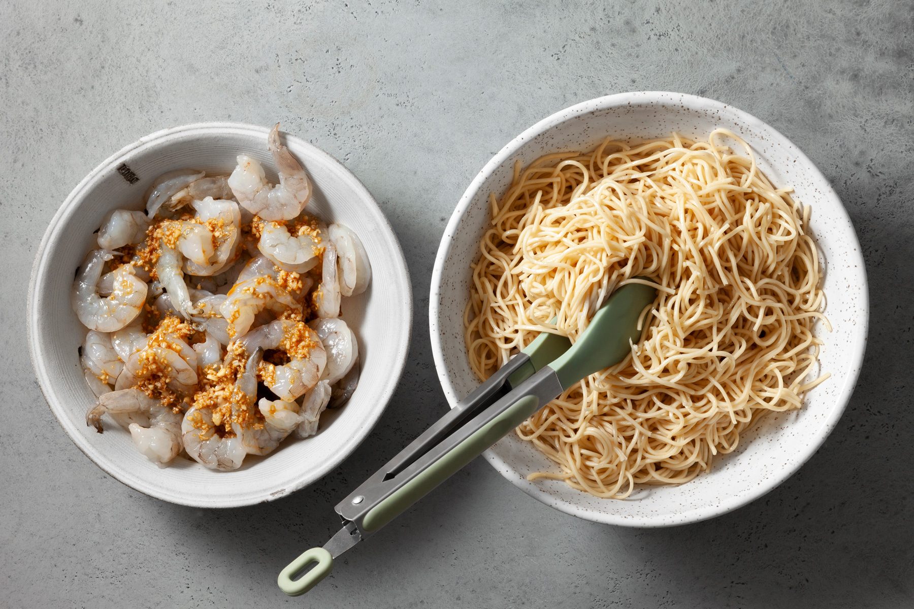 overhead shot of cooked noodles and shrimps n two large bowls