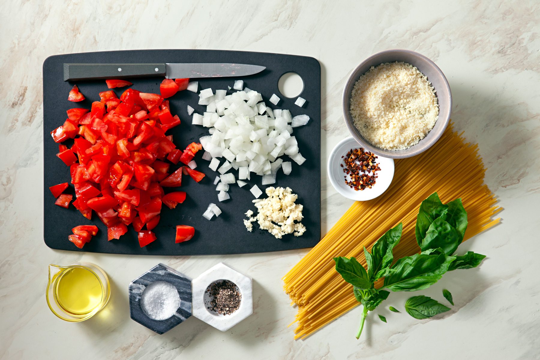 Overhead shot of all ingredients; chopping board; knife; marble surface