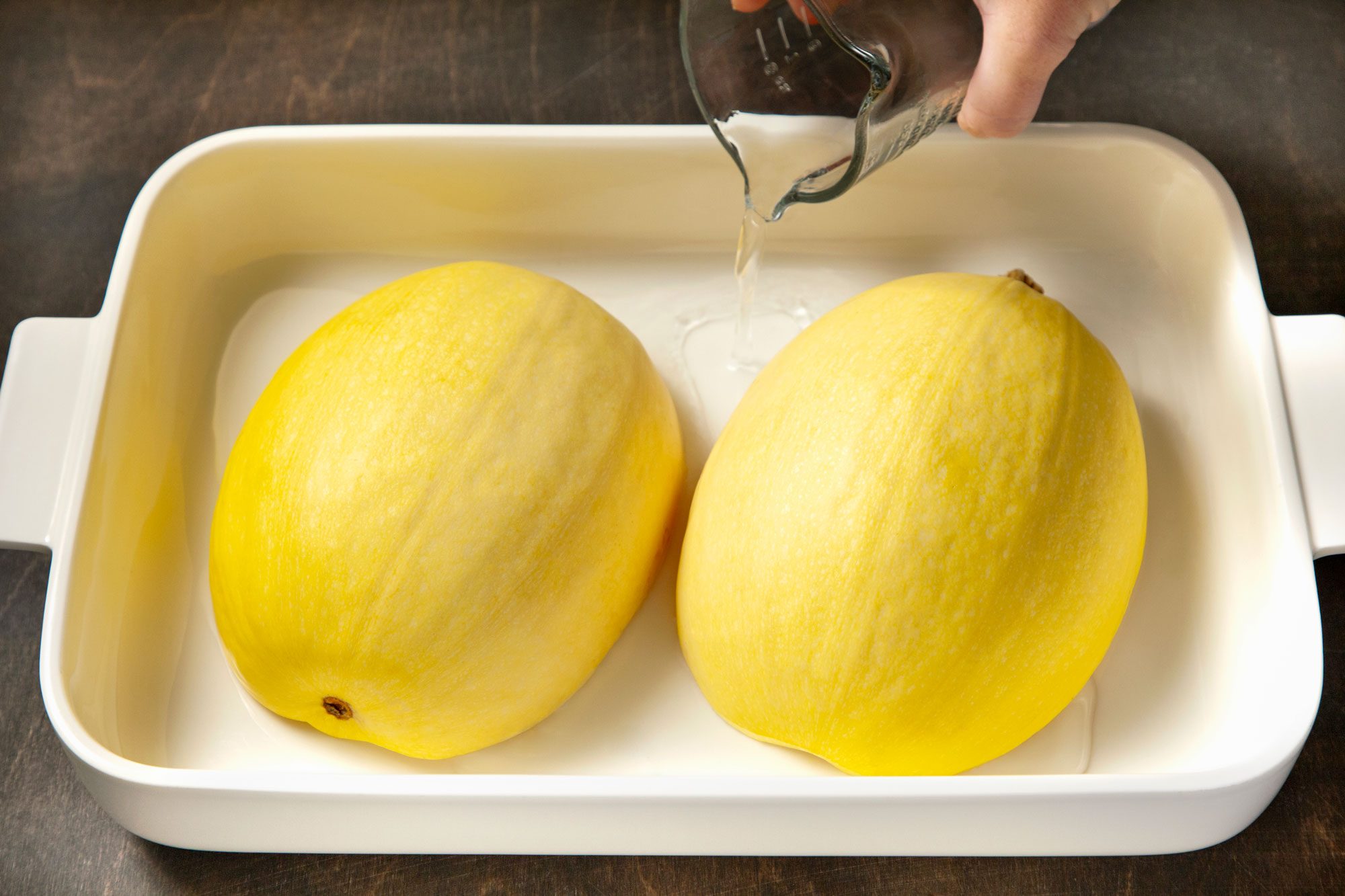 Place cut side down in baking dish; add water.