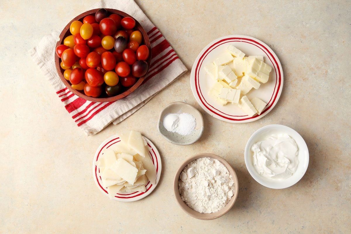 Ingredients for Taste of Home's Tomato Galette in small dishes on a beige marble surface.