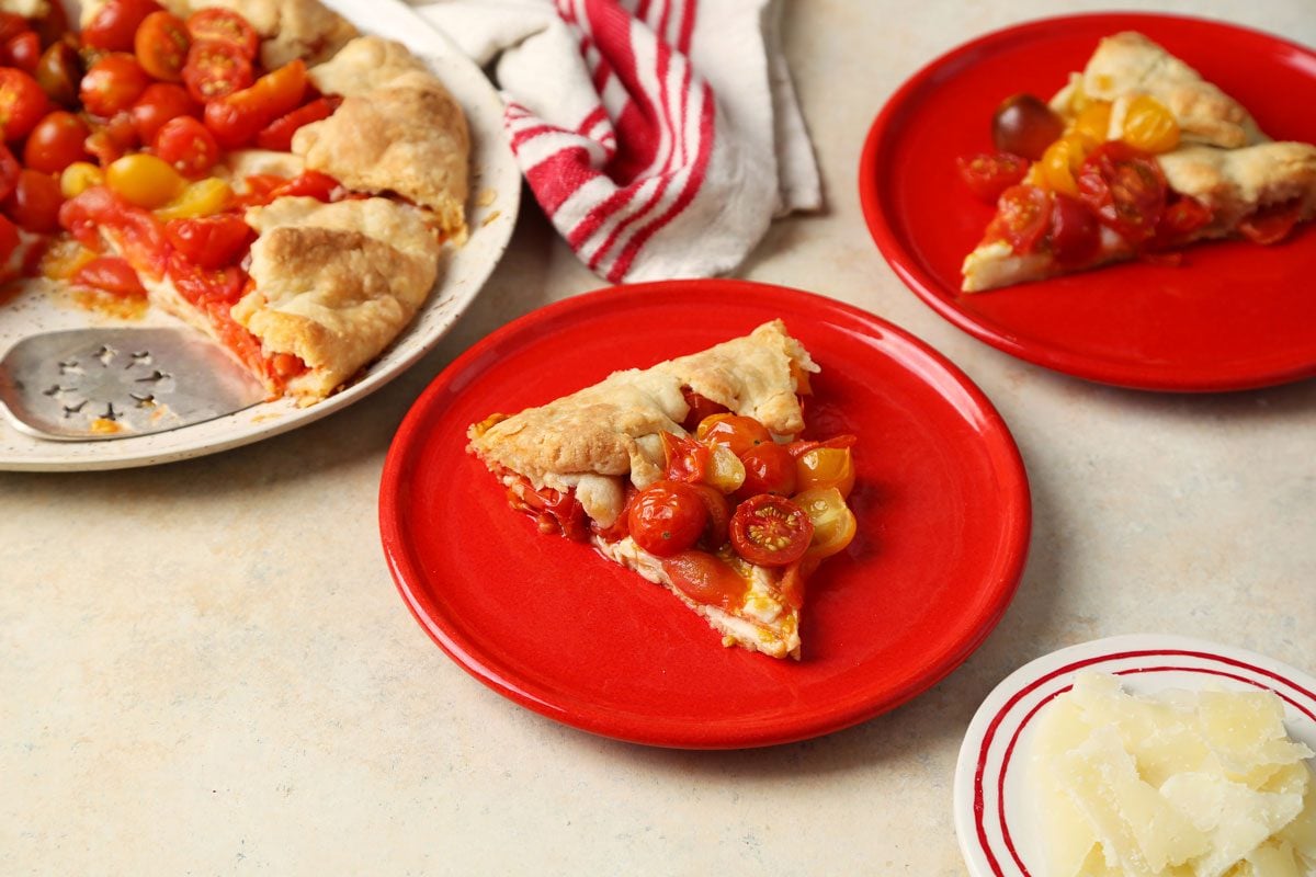 Close up of Taste of Home's Tomato Galette served on a red plate with a beige marble countertop.