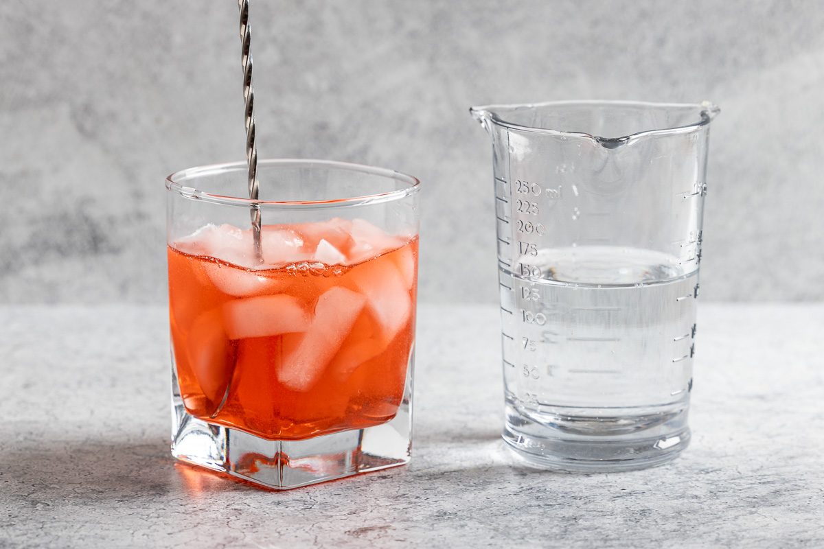 Taste of Home Americano Cocktail photo of mixing the Campari, vermouth, ice, and soda water in a cocktail glass.