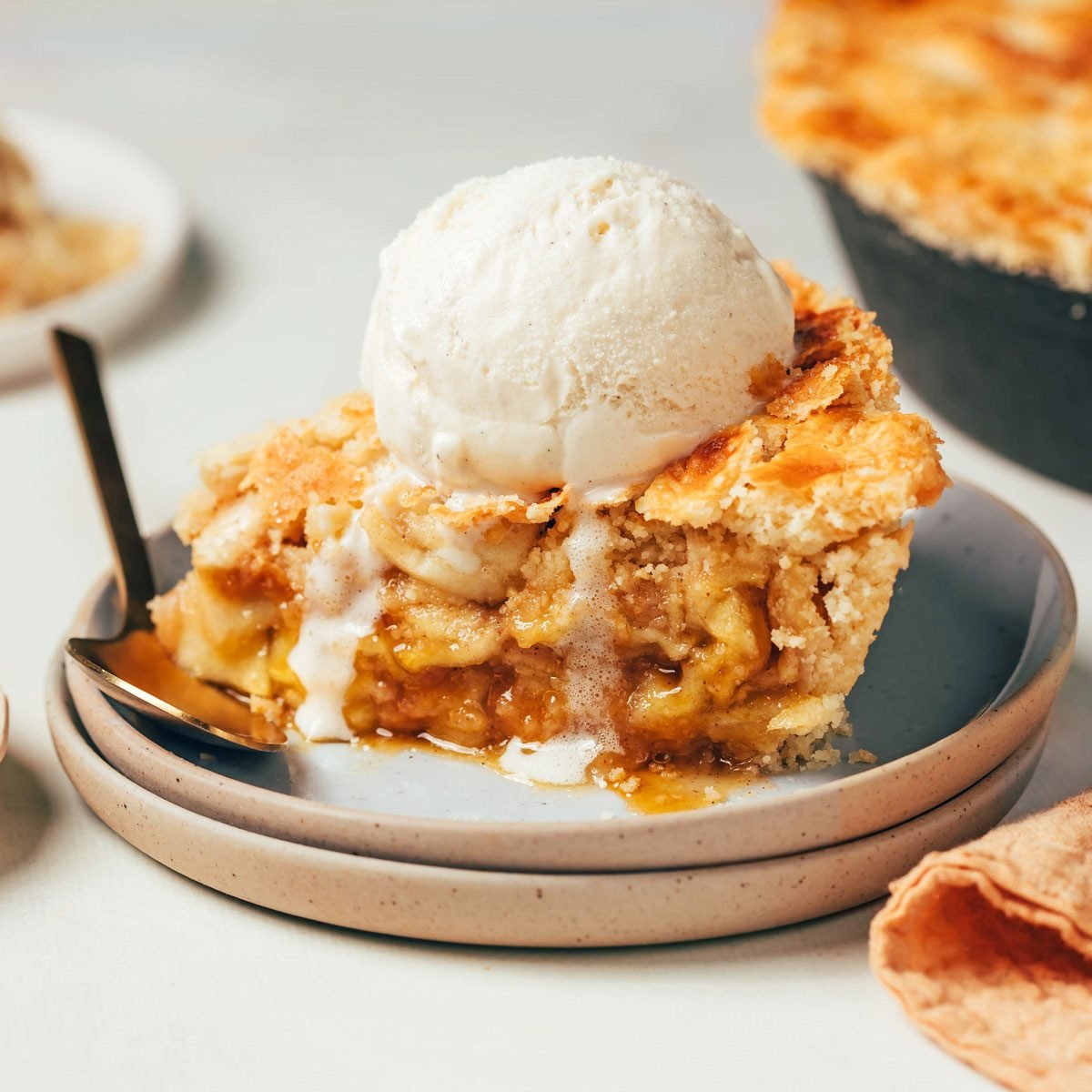 A slice of Cinnamon Apple Pie recipe by Taste of Home topped with melting ice cream