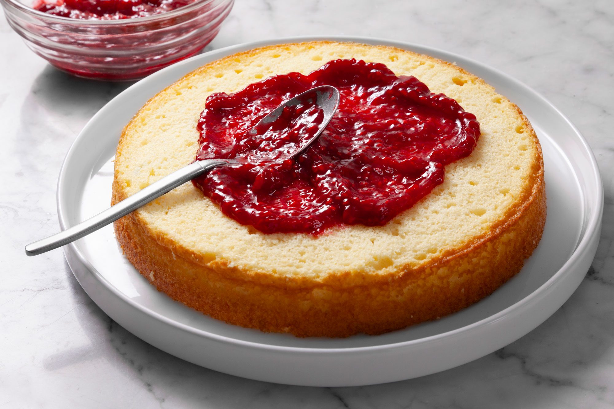 Spread raspberry jam over the top of the cake